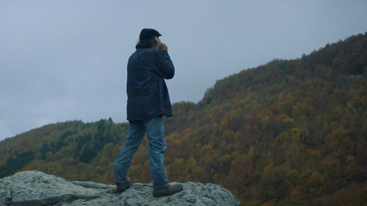Un homme en haut du falaise regarde la forêt. Extrait du film Digger de Georgis Grigorakis