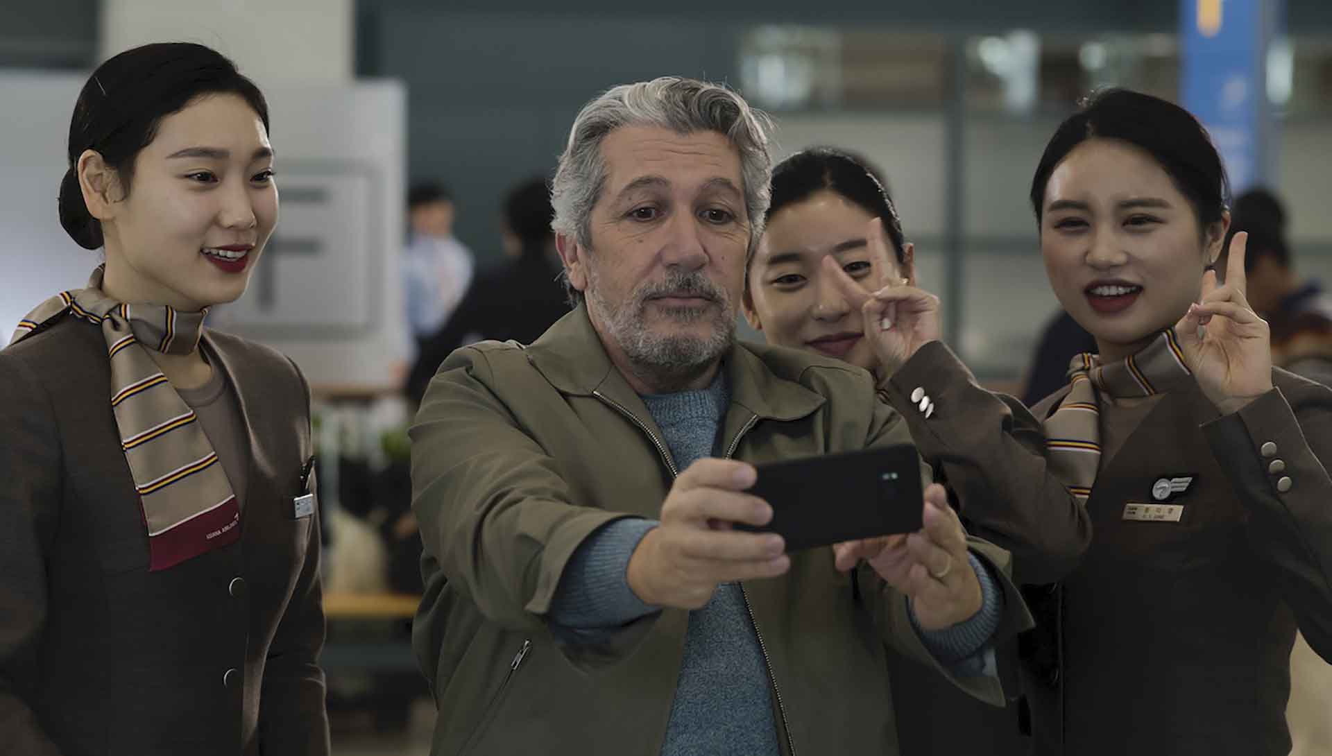 Un homme (Alain Chabat) prenant un selfie en Chine