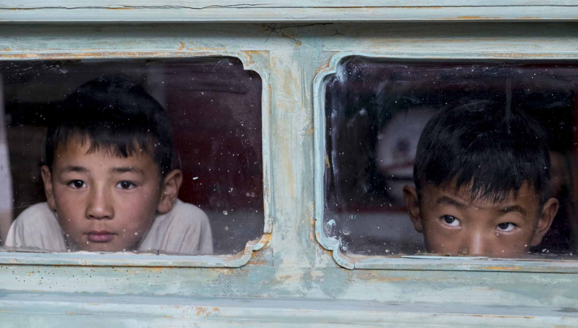Deux enfants regardent par la fenêtre. Extrait du film Balloon de Pema Tseden