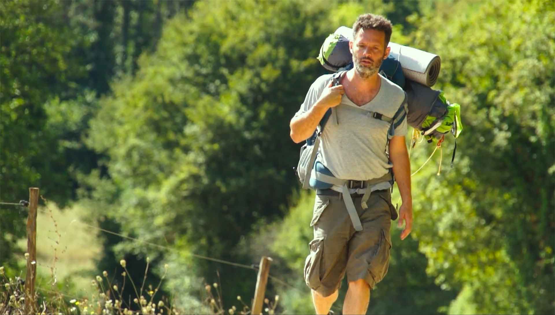 Un homme équipé pour faire du camping, marche en pleine nature. Extrait du film Cyril contre Goliath de Thomas Bornot.