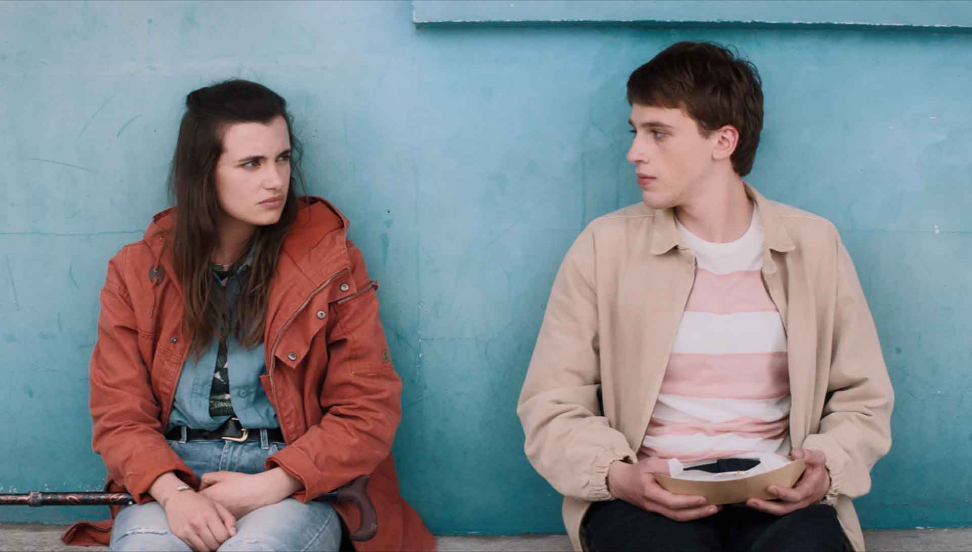 Un homme et une femme se regardent, assis sur un banc.