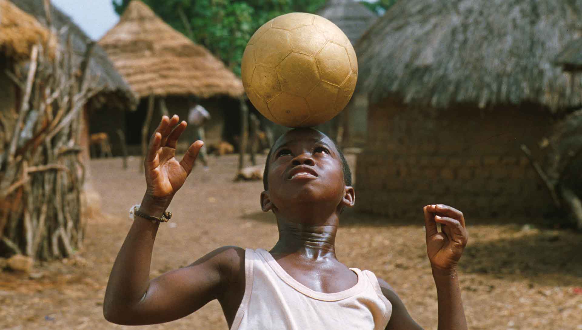 Bandian, un enfant africain joue avec un ballon de foot