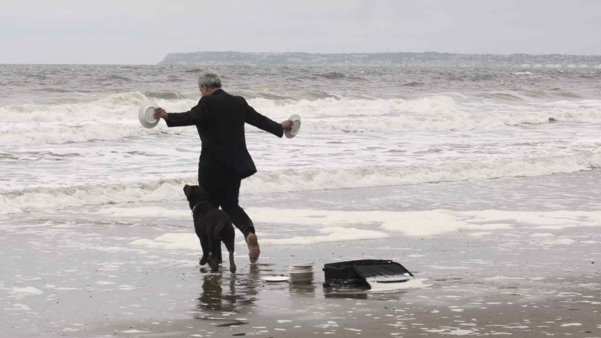 Un homme âgé va à la mer nettoyer ses assiettes