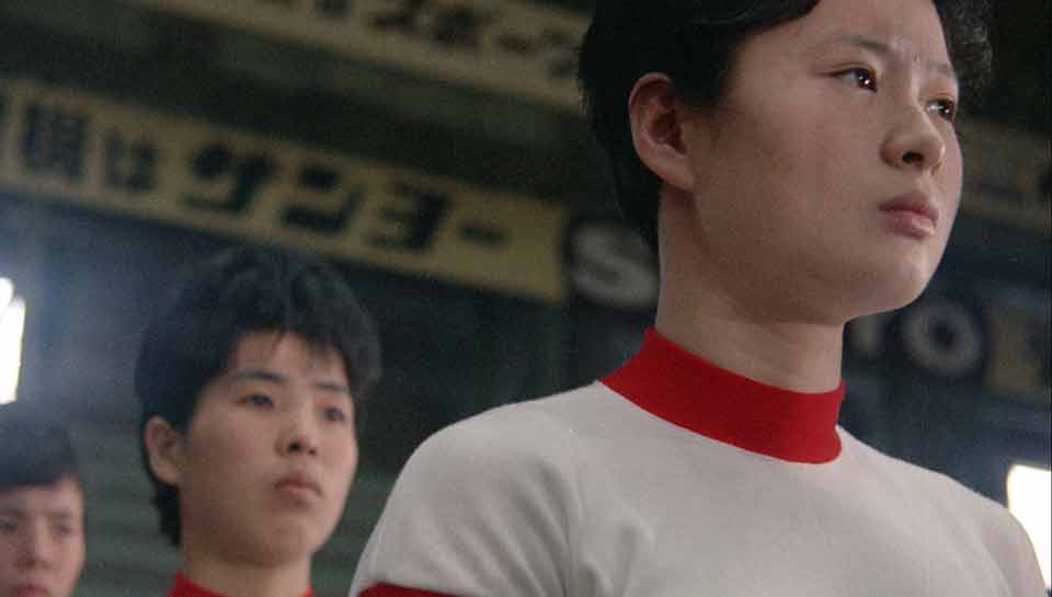 Une joueuse de volley-bal de l'équipe du Japon se tient debout et regarde droit devant elle. Extrait du film Les sorcières de l'Orient de Julien Fauraut 