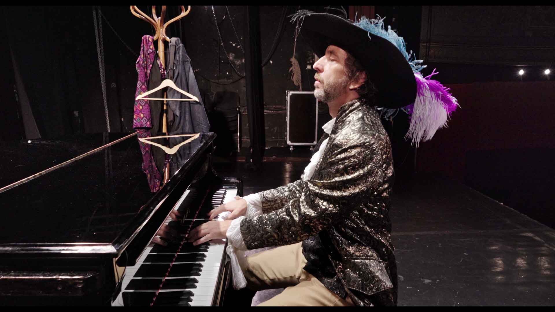 Un homme habillé en mousquetaire joue du piano