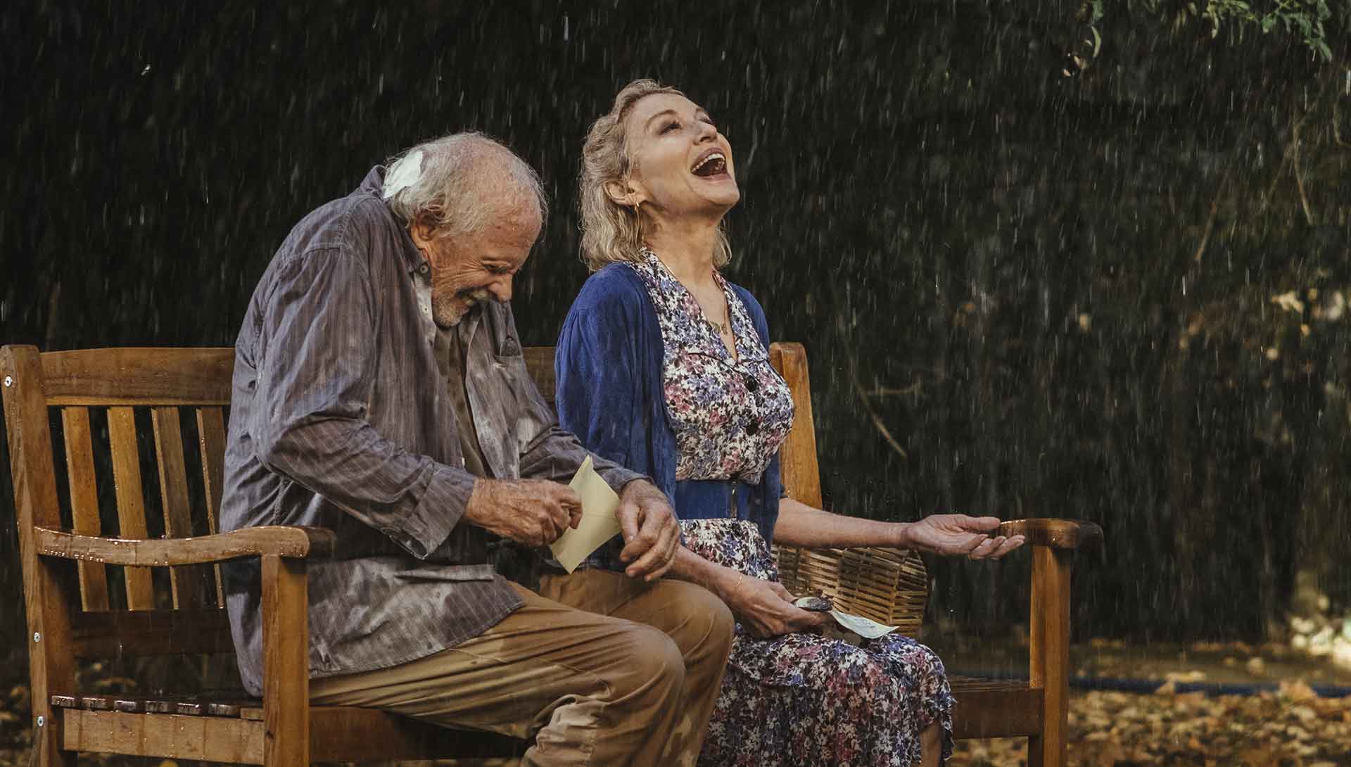 Un homme septuagénaire et une femme quadragénaire rigolent sous la pluie. Extrait du film Remember me de Martin Rosete