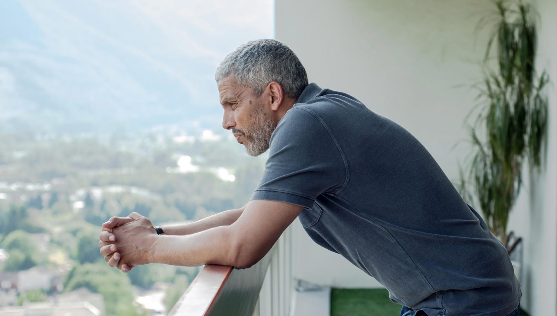 Un homme s'adosse à un balcon. Extrait du 