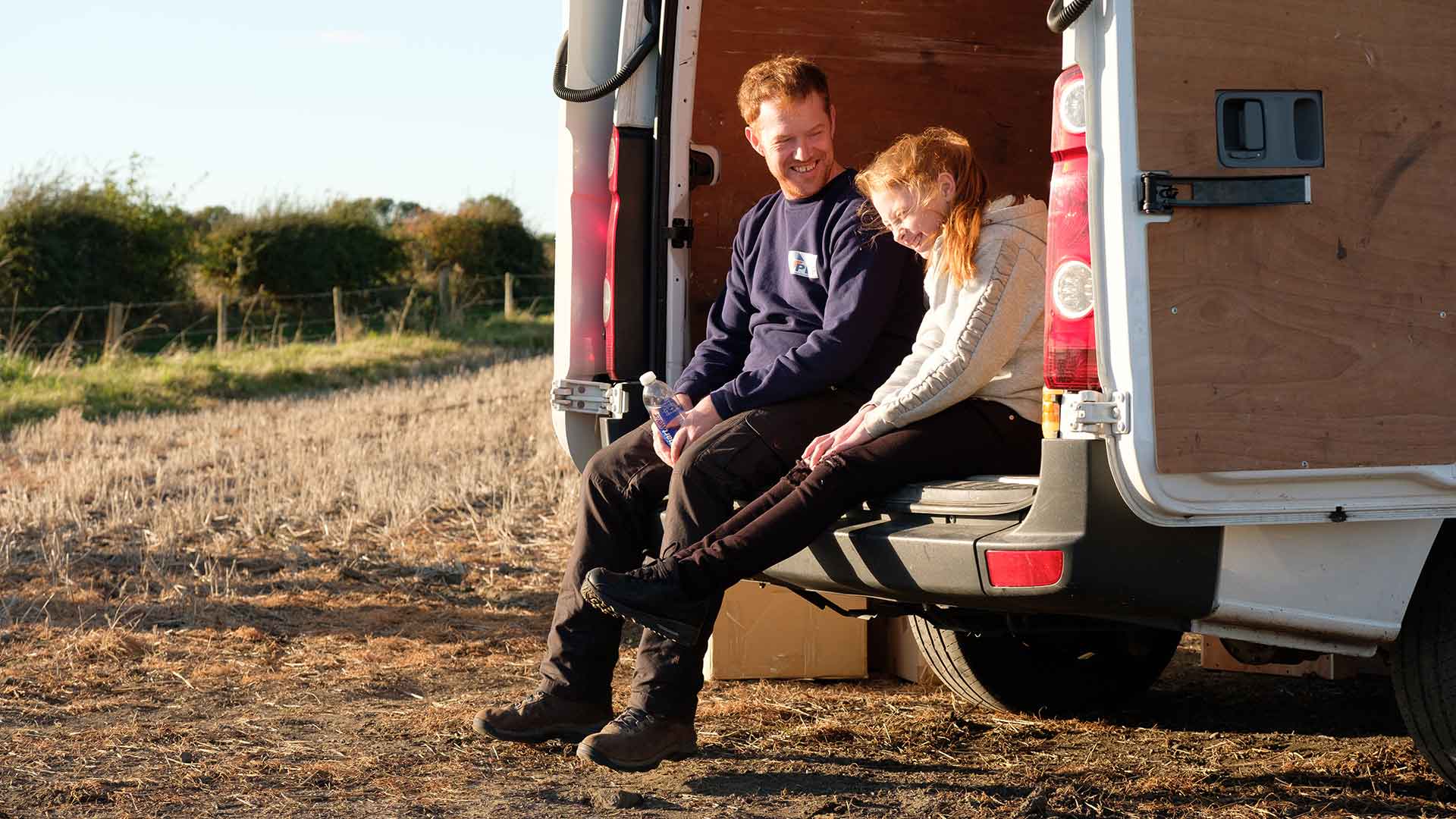 Un père et sa fille rigolent ensemble à la campagne