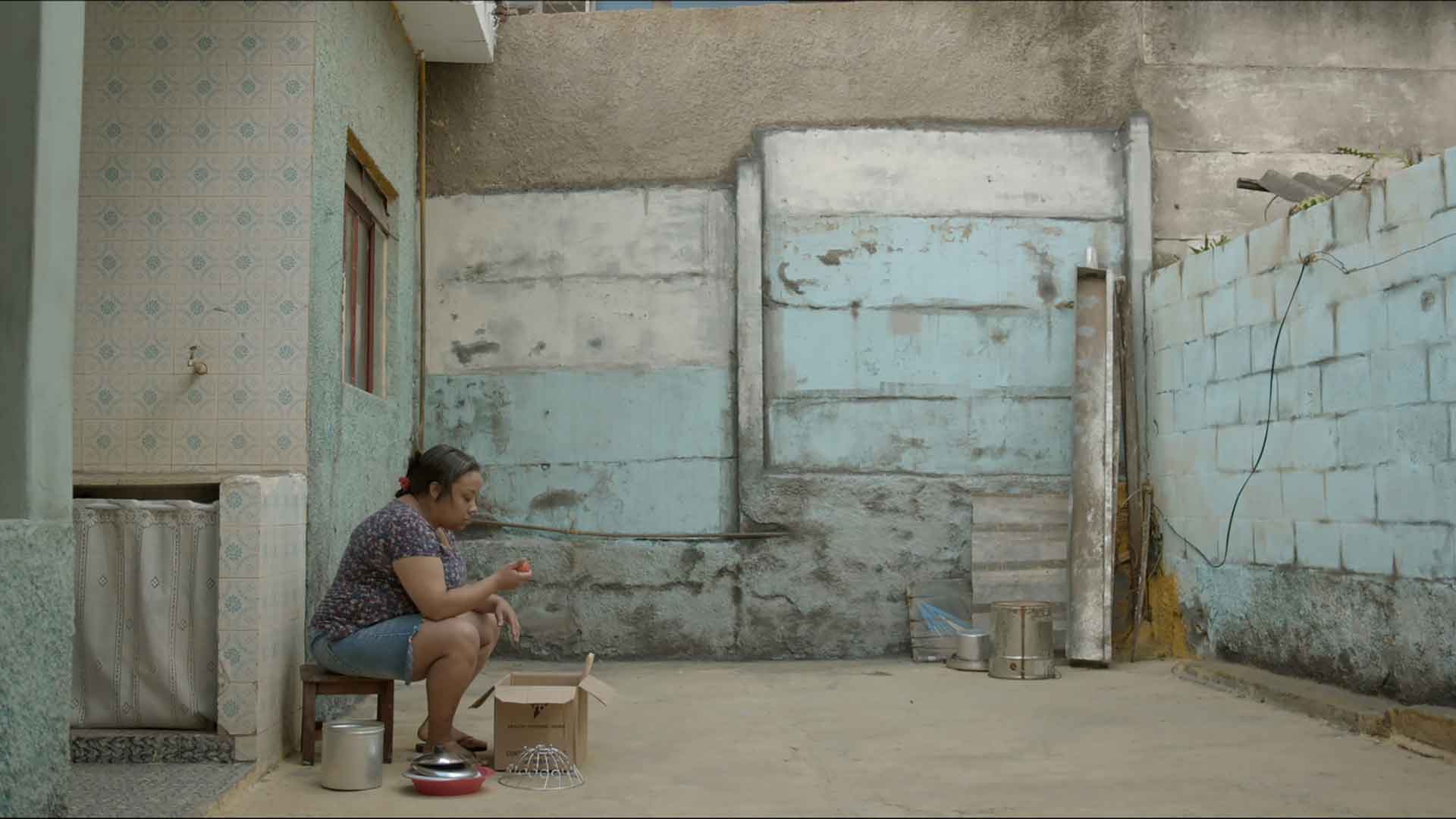 Une femme dans un lieu délabré regarde un fruit