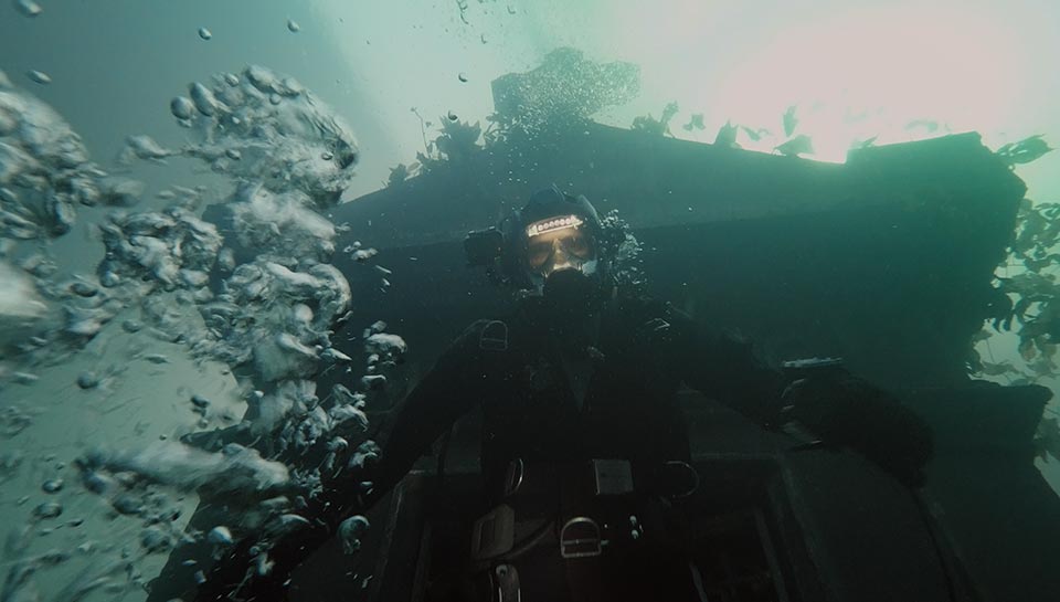 Un plongeur devant une maison sous l'eau. Extrait du film 