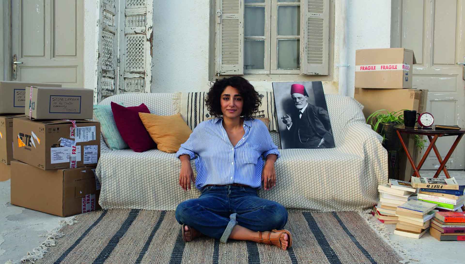 Une femme assise contre un canapé
