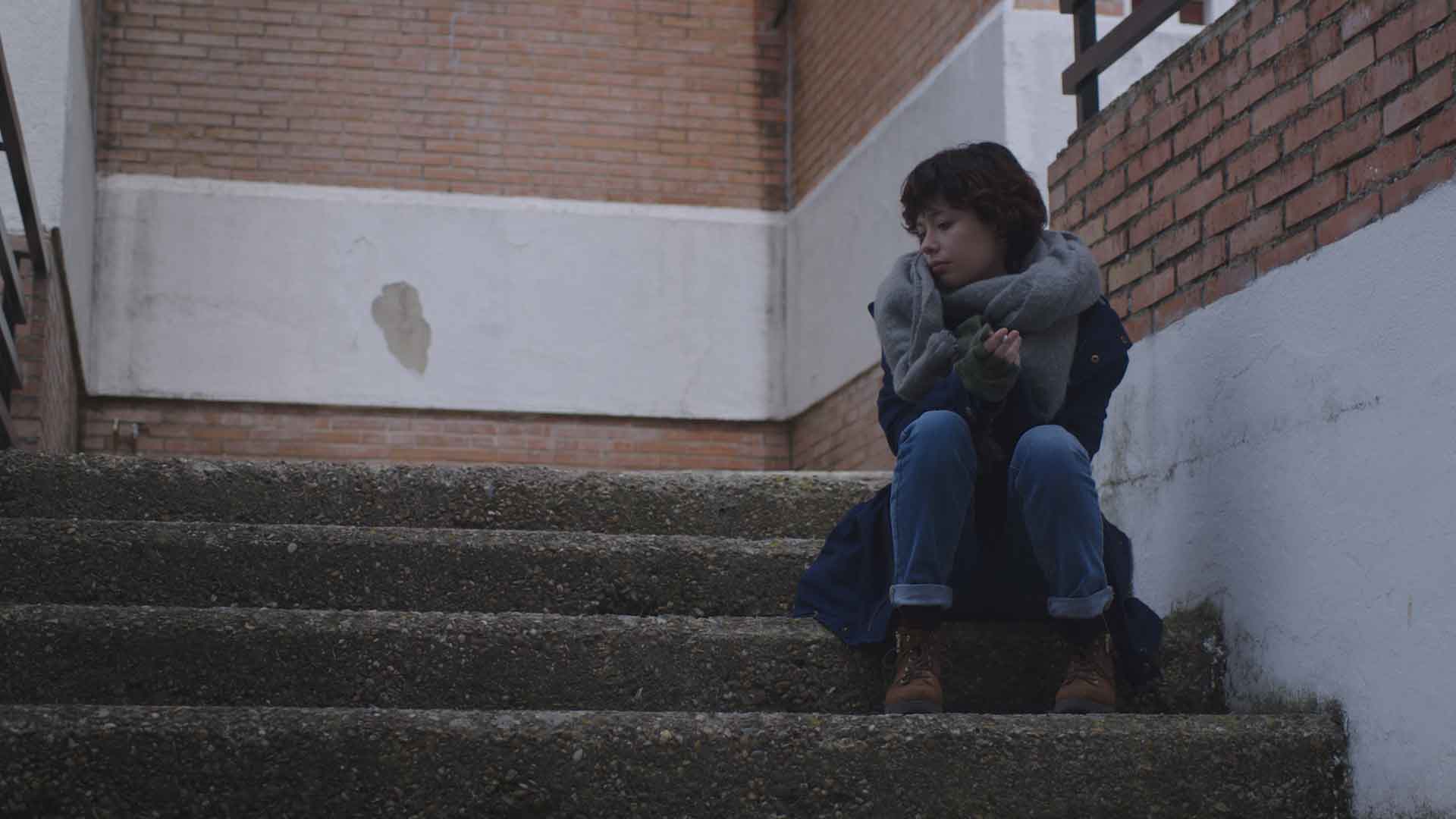 Une femme est assise sur des escaliers
