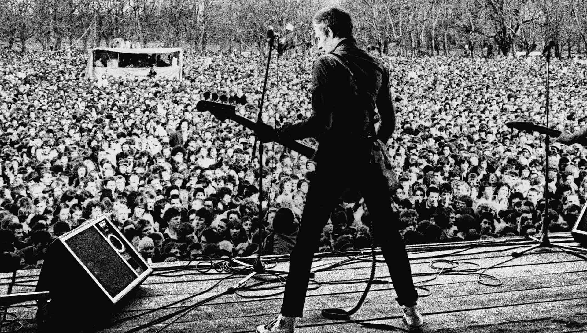 Photo en noir et blanc d'un guitariste devant une foule. Extrait du film White Riot de Rubika Shah