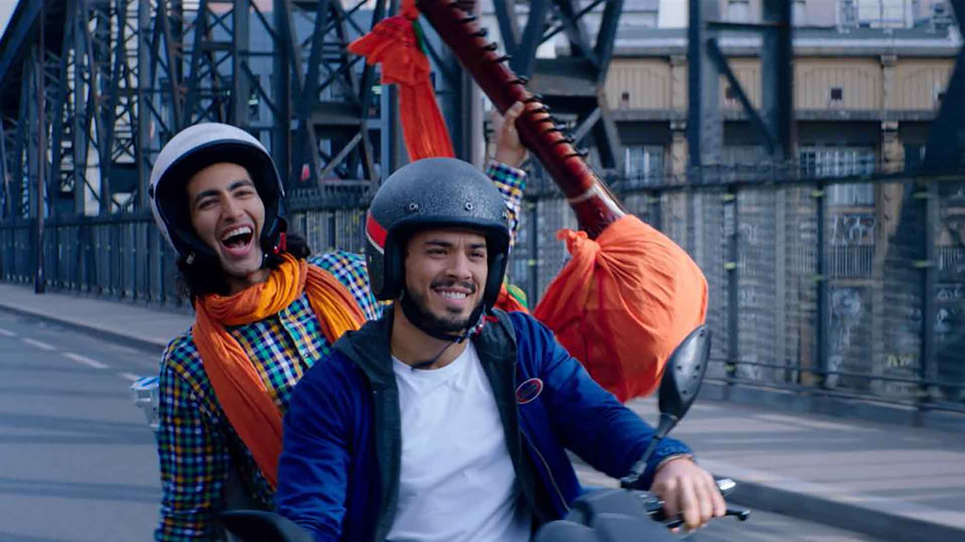 Deux hommes sourient en roulant sur un scooter. Extrait du film Sun de Jonathan Desoindre et Ella Kowalska